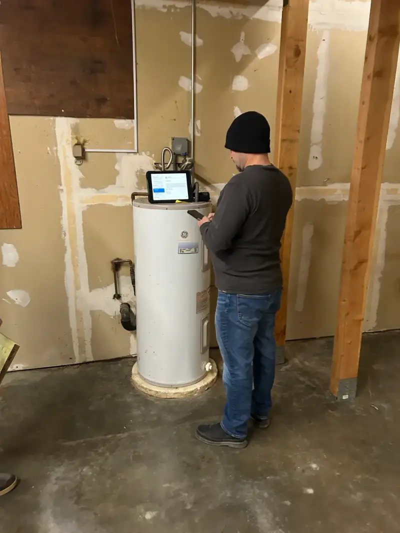 All Phase Plumbing technician commissioning a newly installed electric water heater in a Seattle home
